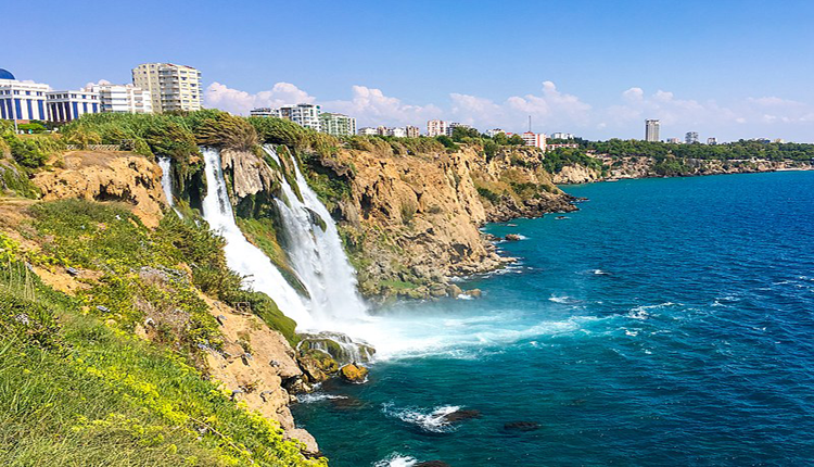 طقس مدينة أنطاليا في تركيا ذات البحر الأزرق المحاط بالصخور والعشب الأخضر
